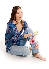 Image showing Confused woman siting on the flor with flowers in hand