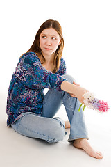 Image showing Lonely woman siting on the flor with flowers in hand