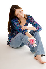 Image showing Romantic woman siting on the flor with flowers in hand