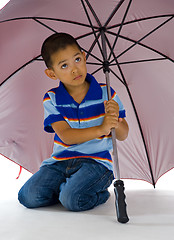 Image showing cute boy under huge umbrella