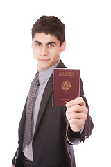 Image showing  A businessman in a suit holds passport