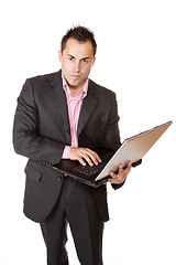 Image showing Happy businessman holding laptop computer