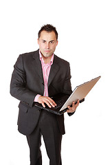 Image showing Happy businessman holding laptop computer