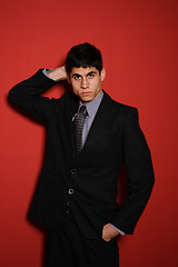 Image showing Young man in suit over red wall