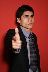 Image showing Young man in suit over red wall