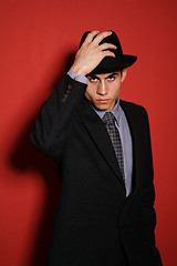 Image showing Young man in suit over red wall