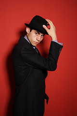 Image showing Young man in suit over red wall