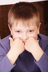Image showing Smiling boy leaning on fists