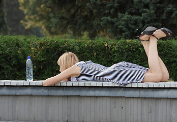 Image showing Blonde laying down on bench 