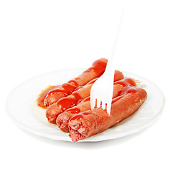 Image showing Sausages dressed with ketchup and fork