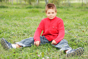 Image showing Boy sitting on grass