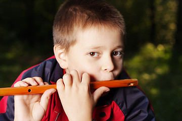 Image showing Boy playing fluite in dark forest