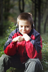 Image showing Boy in dark forest listens music