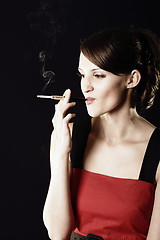 Image showing Smoking young woman in red