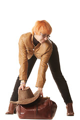 Image showing Redhead traveler puts bag on ground