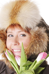 Image showing Redhead in warm hood behind tulips