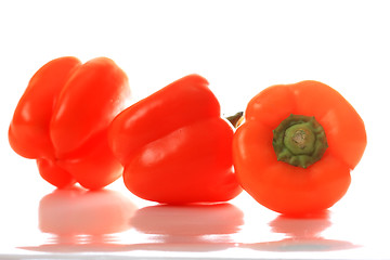 Image showing Three orange paprikas with reflections