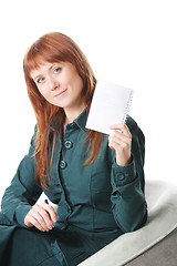 Image showing Redhead in chair showing notepad