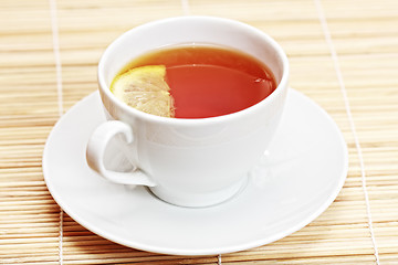 Image showing White cup of tea with lemon