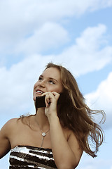 Image showing Fair-haired girl over cloudscape with phone