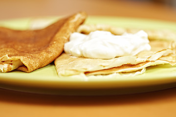 Image showing Green plate with pancakes and sour cream