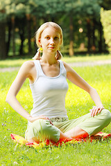 Image showing Blonde in park legs crossed