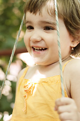 Image showing Smiling girl in swings closeup