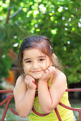 Image showing Smiling girl leaning on fence