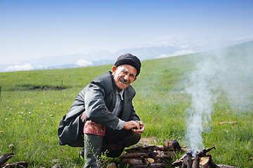 Image showing Elderly man at campfire