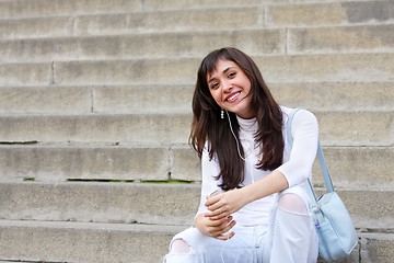 Image showing Smiling brunette on stone steps