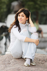 Image showing Girl in casual sitting on stone