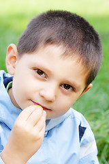 Image showing Boy eats grape