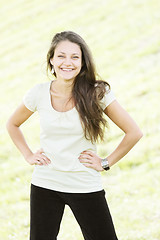 Image showing Smiling brunette hands by sides