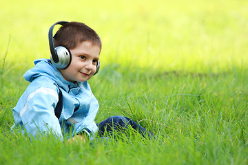 Image showing Serene boy with headphones in meadow