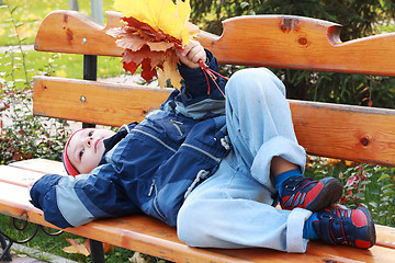 Image showing Serene boy laying on bench