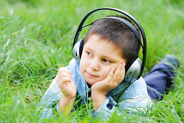 Image showing Kid in grass with headphones