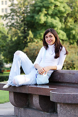 Image showing Smiling girl on stone bench