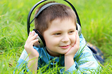 Image showing Boy in grass enjoying music