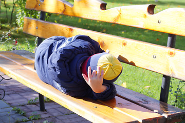Image showing Boy sleeping on bench