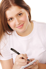 Image showing Smiling redhead with notepad and pen