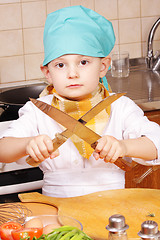 Image showing Little cook sharpening knives