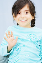 Image showing Little girl raises hand in waving