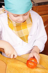 Image showing Little cook with cutting tomato