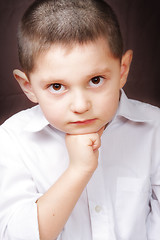 Image showing Boy in white shirt leaning on fist