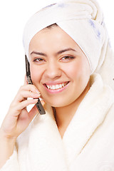 Image showing Smiling woman in bathrobe with phone