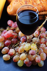 Image showing Glass of red wine covered with grapes