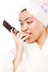 Image showing Expressive woman in bathrobe with mobile