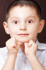 Image showing Boy in white shirt leaning on thumbs