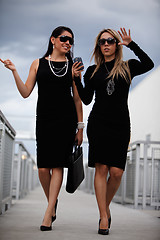 Image showing Two attractive hispanic businesswomen walking outdoor 