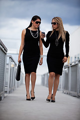 Image showing Two attractive hispanic businesswomen walking outdoor 